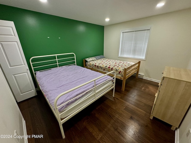 bedroom featuring dark hardwood / wood-style flooring and a baseboard heating unit