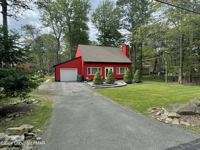 view of front of property with roof with shingles, an attached garage, a chimney, a front lawn, and aphalt driveway