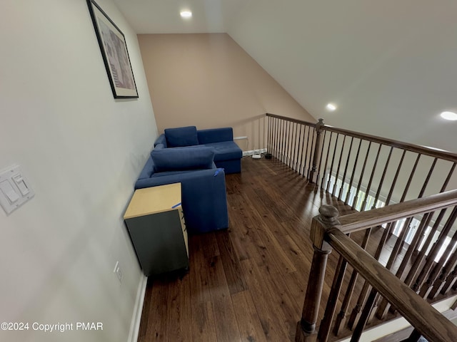 interior space featuring vaulted ceiling, wood finished floors, and baseboards