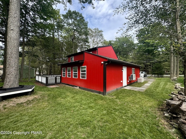 view of home's exterior featuring a wooden deck and a lawn