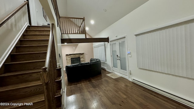 stairway featuring wood-type flooring, high vaulted ceiling, a baseboard heating unit, and a fireplace