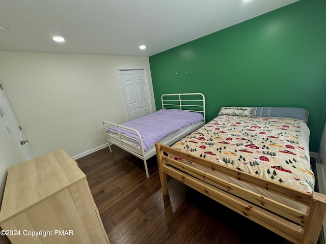 bedroom with dark hardwood / wood-style flooring and a closet