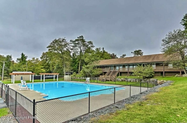 view of swimming pool with an outbuilding and a yard