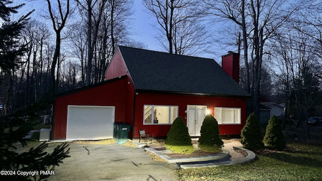 view of front of home with a garage and an outdoor structure