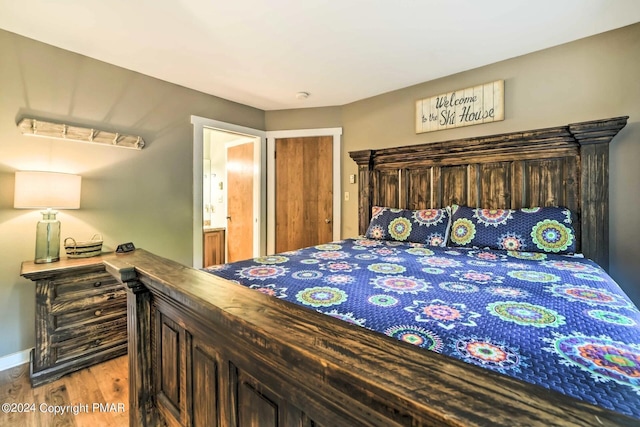 bedroom with wood finished floors and baseboards