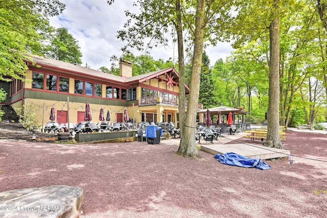 back of house with a gazebo, a patio, and a chimney