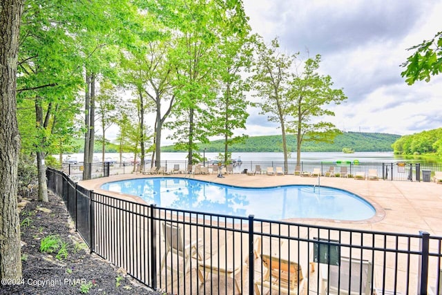 pool with a patio area and fence