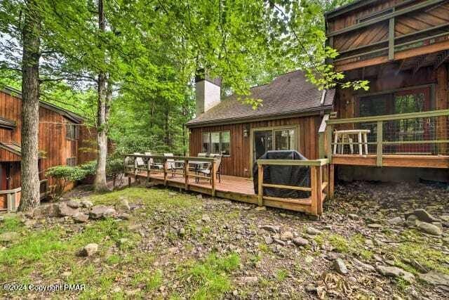 back of property featuring a deck and a chimney