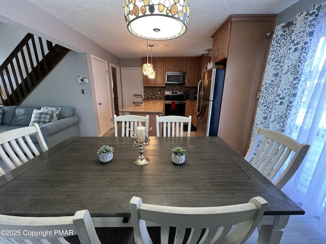 dining room featuring stairway and a textured ceiling