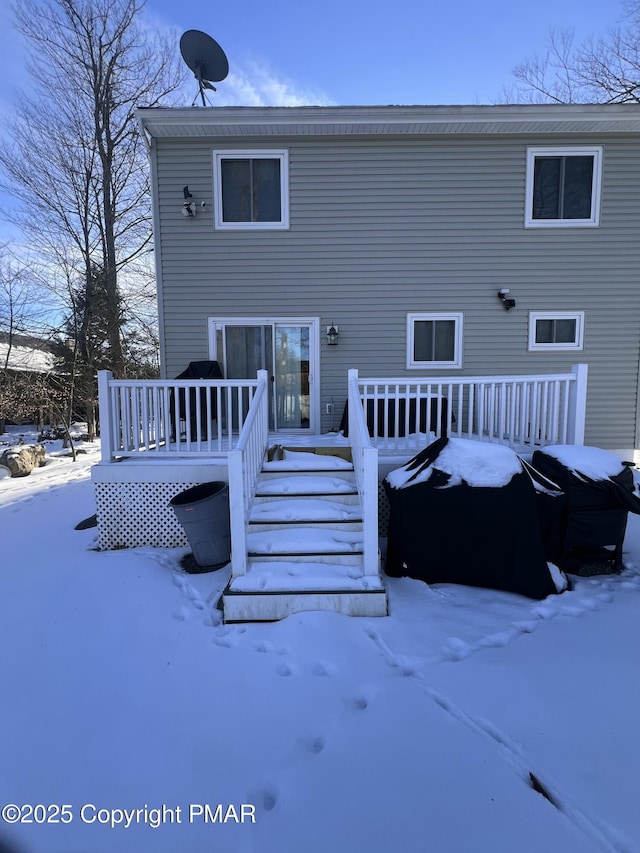 snow covered house featuring a deck