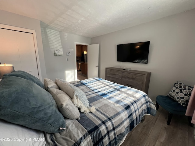 bedroom with a textured ceiling and wood finished floors