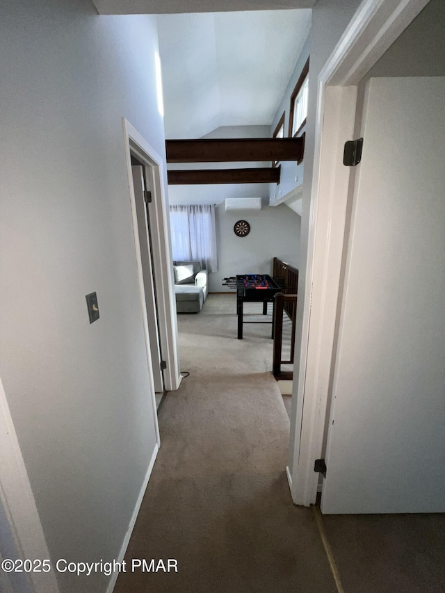 hall with lofted ceiling, carpet, baseboards, and a wall mounted air conditioner