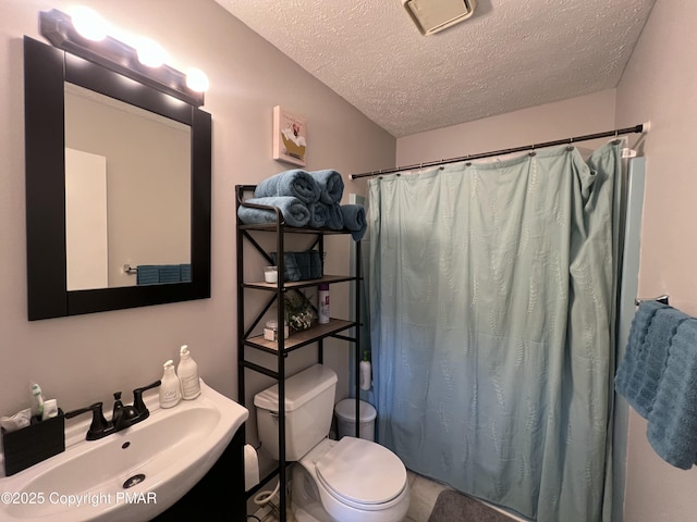 bathroom featuring toilet, a textured ceiling, a sink, and a shower with shower curtain