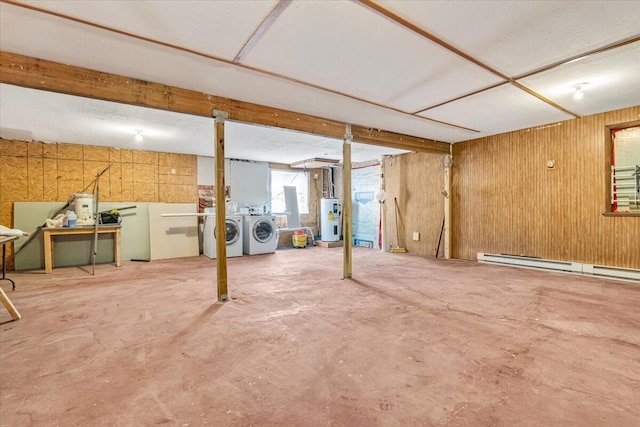 basement featuring water heater, washing machine and dryer, a baseboard heating unit, and wooden walls