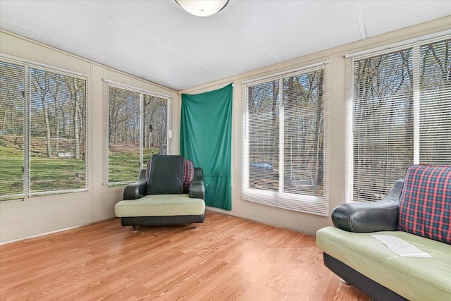 sunroom / solarium featuring wood finished floors and lofted ceiling
