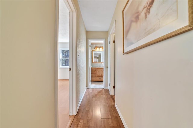 hallway with baseboards and light wood-type flooring