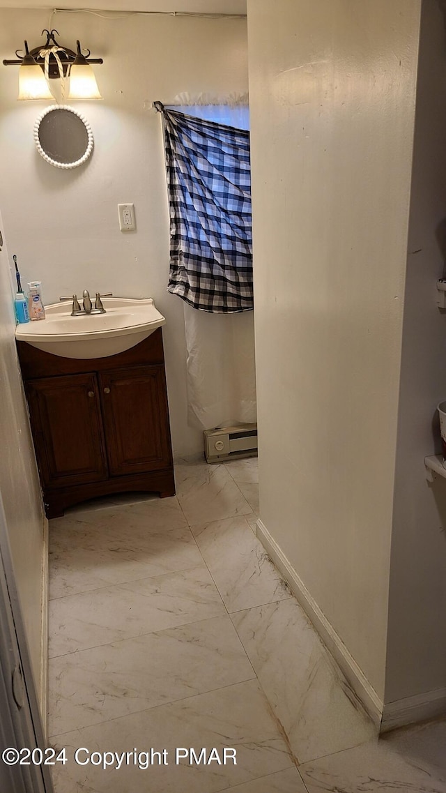 bathroom with marble finish floor, vanity, and baseboards