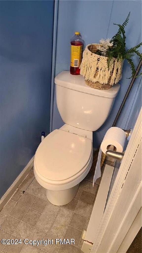 bathroom featuring toilet and baseboards