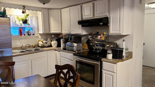 kitchen featuring a toaster, appliances with stainless steel finishes, white cabinets, a sink, and under cabinet range hood