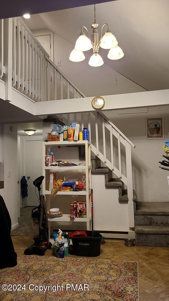 staircase with a towering ceiling and an inviting chandelier