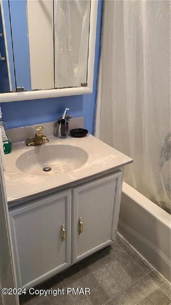 bathroom with shower / bath combination with curtain and vanity