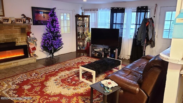 tiled living area featuring a lit fireplace