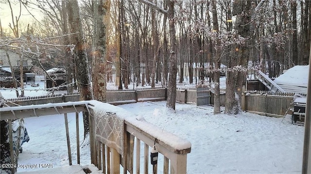 yard layered in snow featuring fence