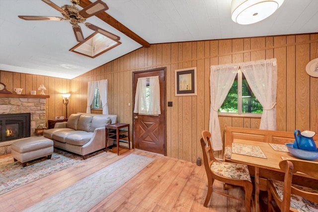 115 Alpine Ct, Pocono Pines, PA 18350 - living area featuring baseboard heating, hardwood / wood-style floors, a ceiling fan, wooden walls, and a stone fireplace