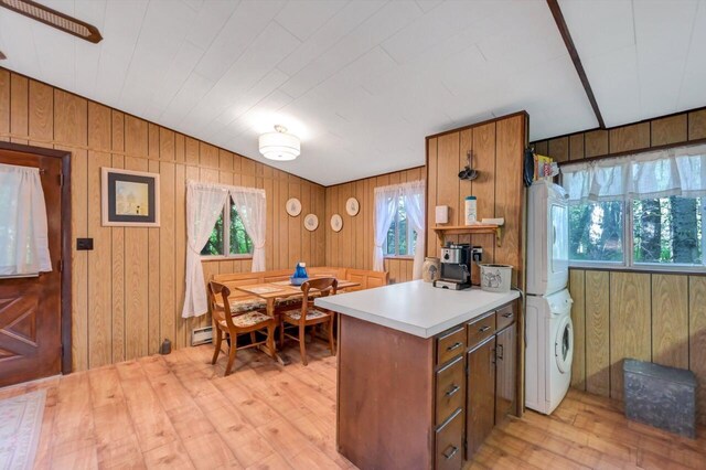 115 Alpine Ct, Pocono Pines, PA 18350 - kitchen with estacked washer and dryer, light wood-style floors, light countertops, brown cabinets, and wooden walls