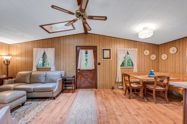 115 Alpine Ct, Pocono Pines, PA 18350 - living area featuring light wood-style floors, ceiling fan, vaulted ceiling, wooden walls, and baseboard heating