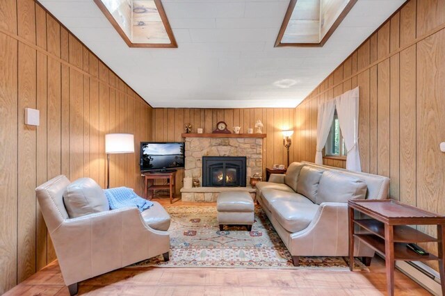 115 Alpine Ct, Pocono Pines, PA 18350 - living area featuring wood finished floors, wood walls, a baseboard heating unit, and a fireplace