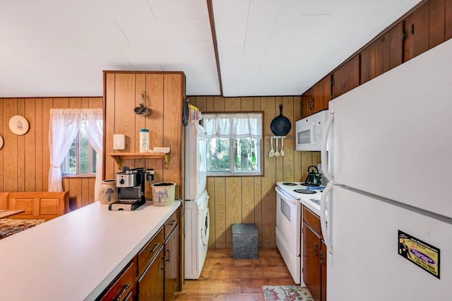 115 Alpine Ct, Pocono Pines, PA 18350 - kitchen with white appliances, estacked washer and dryer, healthy amount of natural light, light countertops, and wood walls