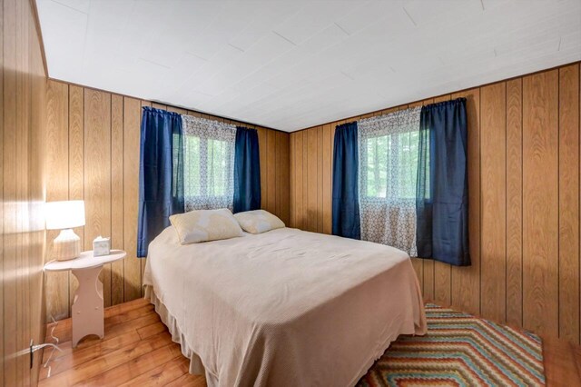 115 Alpine Ct, Pocono Pines, PA 18350 - bedroom with multiple windows, wood walls, and wood finished floors