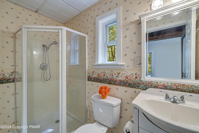 full bath with toilet, a stall shower, vanity, and wallpapered walls