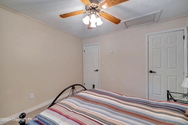 bedroom with baseboards, a textured ceiling, attic access, and carpet