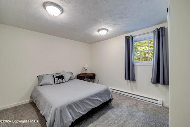 bedroom featuring a baseboard heating unit, baseboards, a textured ceiling, and carpet flooring