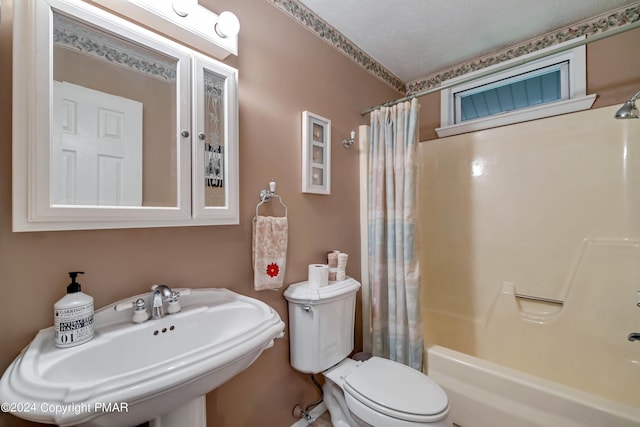 bathroom with a sink, toilet, a textured ceiling, and shower / bath combination with curtain