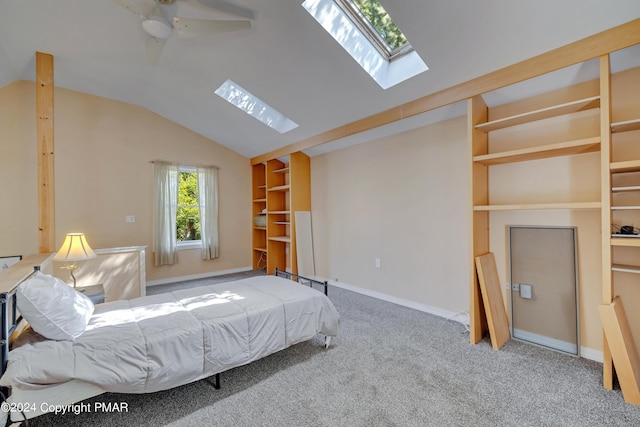 unfurnished bedroom featuring baseboards, lofted ceiling with skylight, carpet, and a ceiling fan