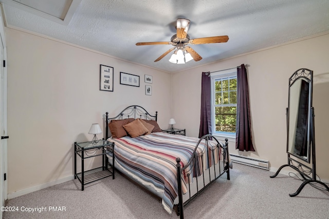 bedroom featuring a baseboard heating unit, baseboards, light colored carpet, and a textured ceiling