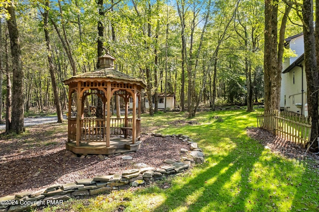 view of yard featuring a gazebo, a view of trees, and fence