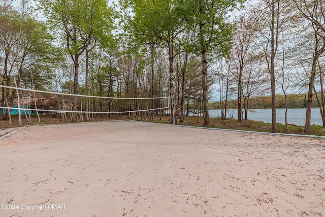 view of home's community with a water view and volleyball court