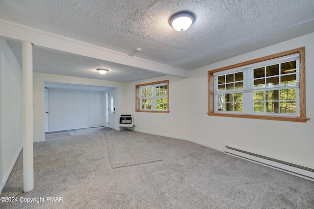 spare room featuring heating unit, a textured ceiling, a baseboard heating unit, and carpet floors