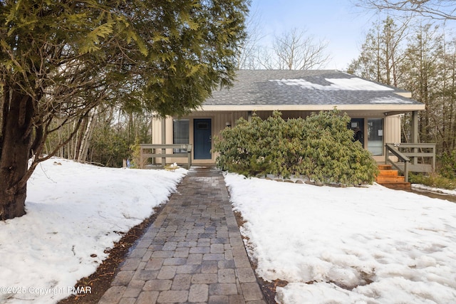 view of front of house with covered porch and a shingled roof