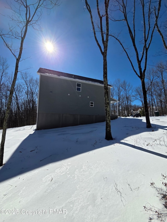 snow covered property with a detached garage