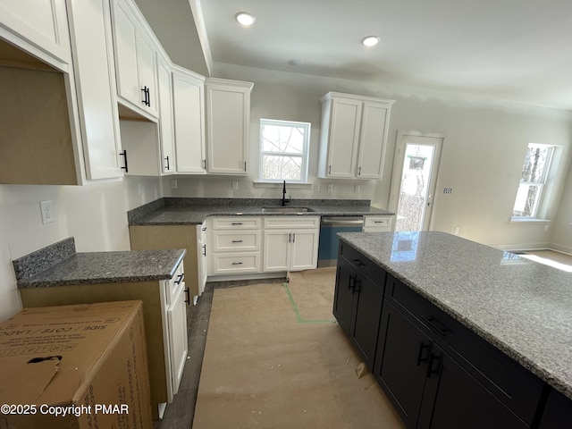 kitchen with recessed lighting, a sink, white cabinetry, dark cabinetry, and dishwasher