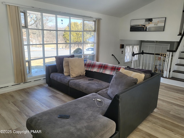 living area featuring stairs, vaulted ceiling, and wood finished floors