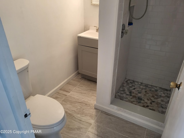 full bathroom featuring a stall shower, vanity, toilet, and baseboards