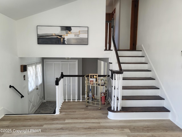 stairway featuring vaulted ceiling and wood finished floors