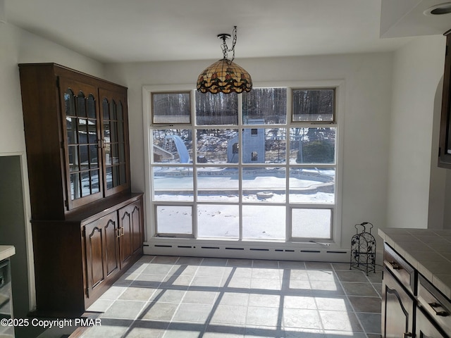 dining area with light tile patterned floors, baseboard heating, and a wealth of natural light