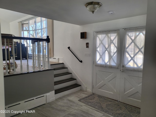 foyer entrance with baseboard heating and plenty of natural light